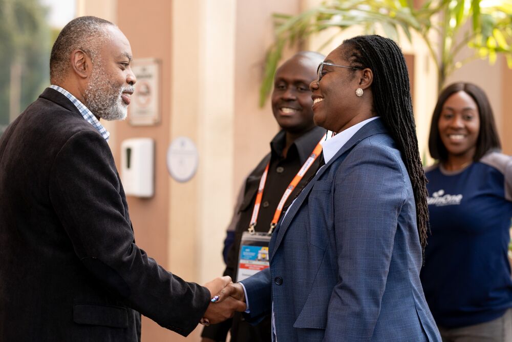 A man and woman shake their hands smiling