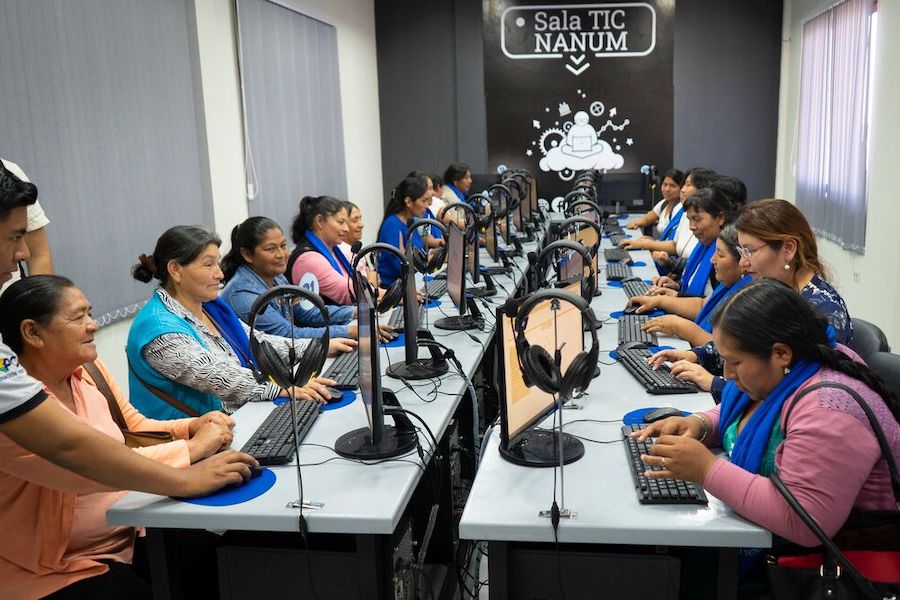 un grupo de mujeres navegando por Internet en una enorme sala de conferencias