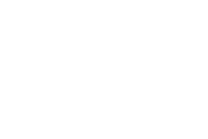 A man kneels and writes on a large chalkboard